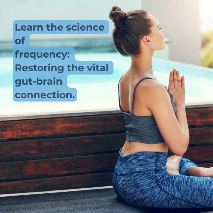 A woman in athletic wear sitting in a yoga pose with hands in prayer position by a swimming pool.